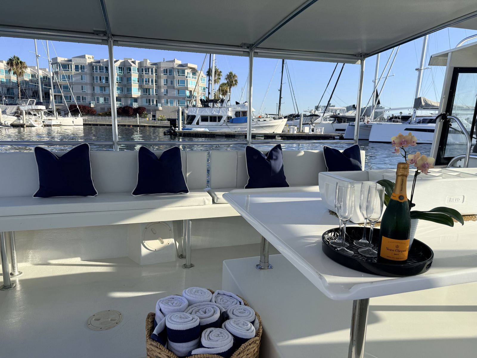 Onboard table set with glassware and navy-cushioned seating aboard Aurora Sol in Marina del Rey